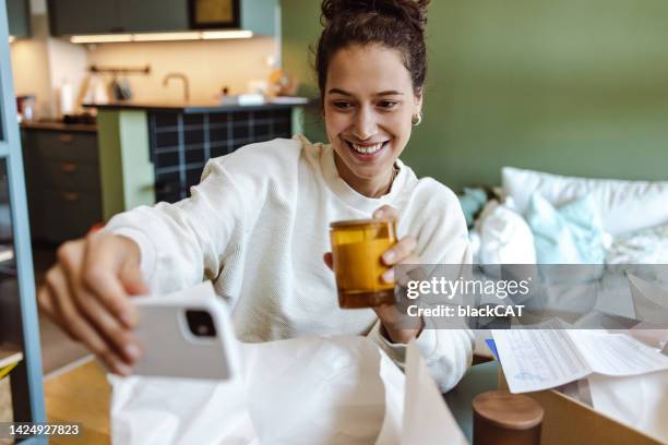 influencer femenina tomando una selfie con el artículo pedido - persuasión fotografías e imágenes de stock