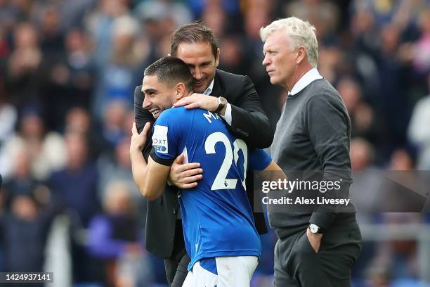 Frank Lampard, Manager of Everton celebrates with Neal Maupay of Everton as David Moyes , Manager of West Ham United looks dejected following the...