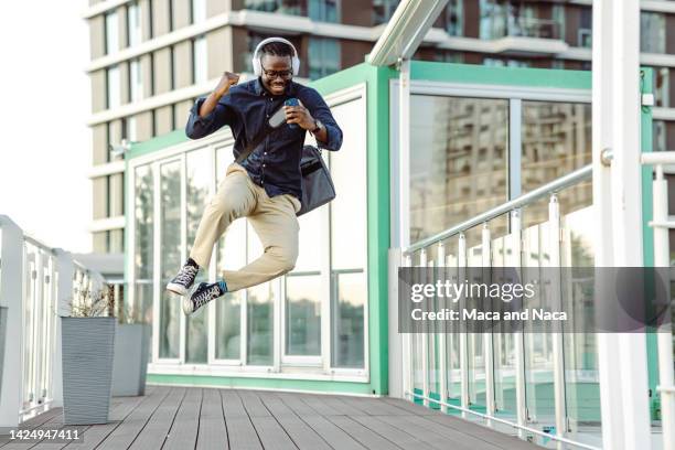 photo of a happy and successful businessmen jumping in the air - phone mid air stock pictures, royalty-free photos & images