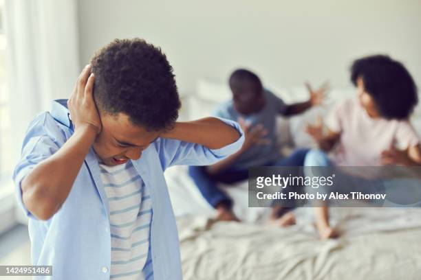 little african boy suffers from quarrelling parents pose on young mom and dad screaming sorting their relationships on background. - lucho en familia fotografías e imágenes de stock