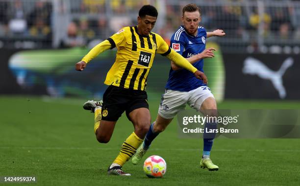 Jude Bellingham of Dortmund is challenged by Tobias Mohr of Schalke during the Bundesliga match between Borussia Dortmund and FC Schalke 04 at Signal...