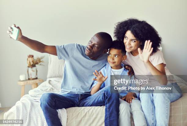 african parents and little son greeting family start video call using smartphone and videocall application - alex pix photos et images de collection