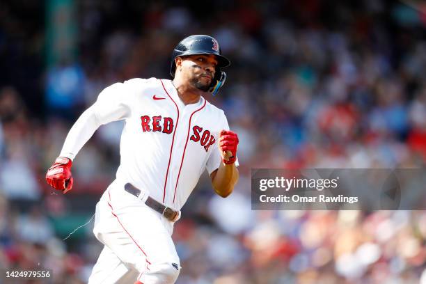 Xander Bogaerts of the Boston Red Sox rounds first base after hitting an RBI double in the bottom of the first inning of the game against the Kansas...