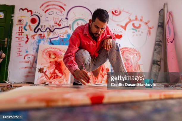 talented male artist working on a modern abstract oil painting - man stand stockfoto's en -beelden