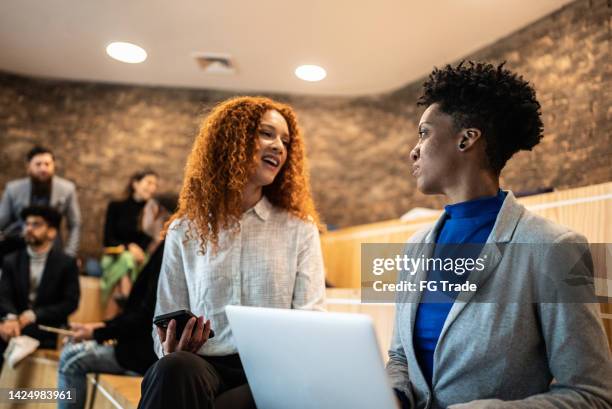 geschäftsfrauen sprechen und benutzen laptop bei einem meeting bei einer arbeit - member meeting stock-fotos und bilder