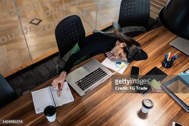exhausted businesswoman napping in the office - office solitude stock pictures, royalty-free photos & images