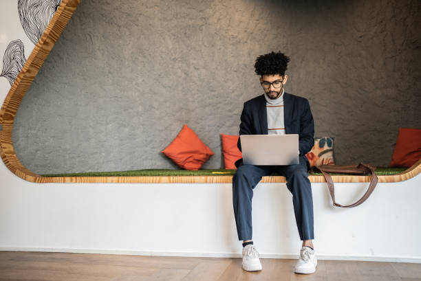 mid adult man using the laptop at the office - modern stock pictures, royalty-free photos & images