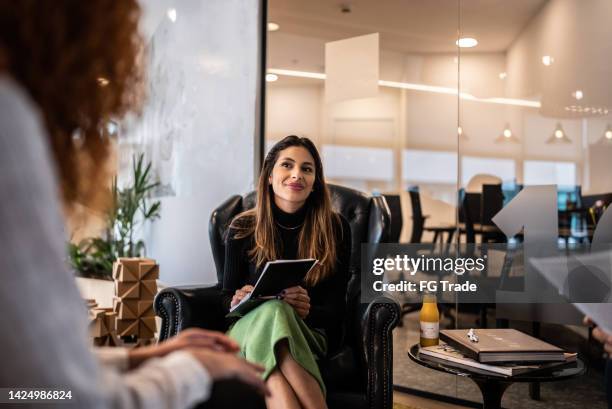 young woman in a meeting with coworkers at the office - werf stockfoto's en -beelden