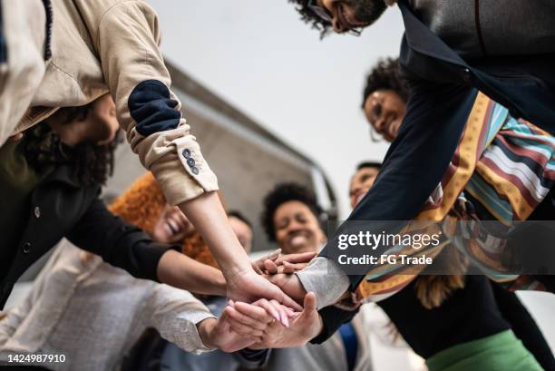 colleghi con le mani impilate in ufficio - business working together foto e immagini stock