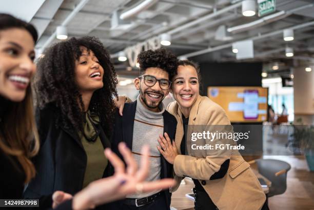 coworkers embracing and talking at the office - community meeting bildbanksfoton och bilder