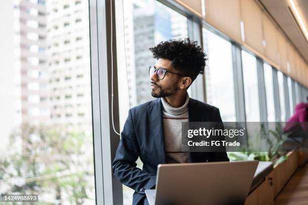 businessman contemplating in the office looking through the window - waiting anticipation stock pictures, royalty-free photos & images