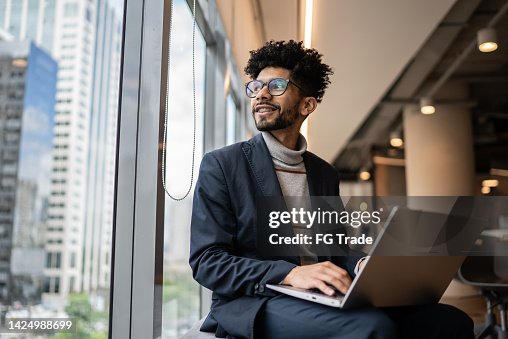 Businessman contemplating in the office looking through the window Businessman contemplating in the office looking through the window