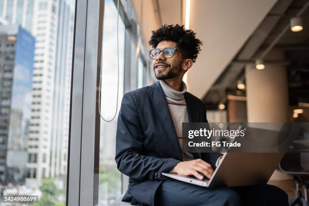 businessman contemplating in the office looking through the window - occupation bildbanksfoton och bilder