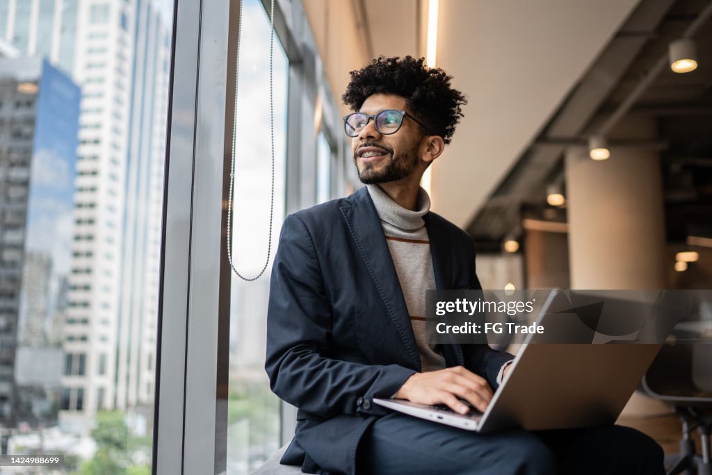 Businessman contemplating in the office looking through the window