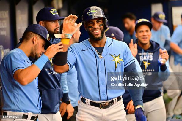 Yandy Diaz of the Tampa Bay Rays celebrates with teammates after scoring in the third inning against the Texas Rangers at Tropicana Field on...