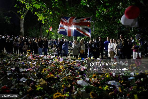 People observe one minute of silence and reflection on the life of Queen Elizabeth II in the floral tribute area in Green Park near Buckingham Palace...