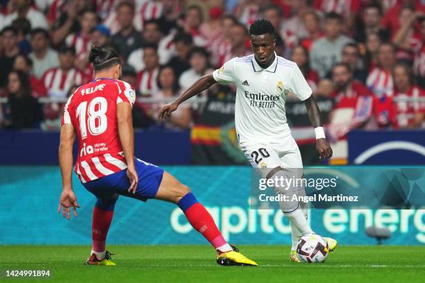 Vinicius Junior of Real Madrid is put under pressure by Felipe of Atletico de Madrid during the LaLiga Santander match between Atletico de Madrid and...