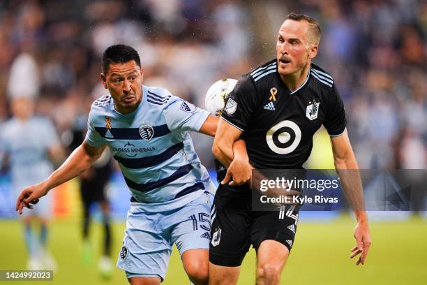 Roger Espinoza of Sporting Kansas City and Brent Kallman of Minnesota United battle for possession during the second half at Children's Mercy Park on...
