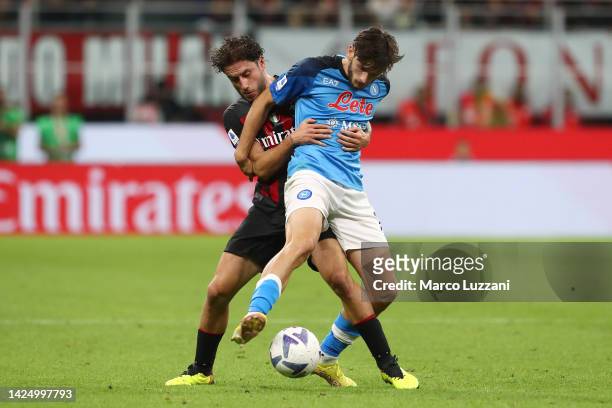 Khvicha Kvaratskhelia of SSC Napoli is challenged by Davide Calabria of AC Milan during the Serie A match between AC Milan and SSC Napoli at Stadio...