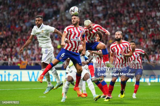 Koke of Atletico de Madrid heads the ball from teammate Antoine Griezmann and Rodrygo of Real Madrid during the LaLiga Santander match between...
