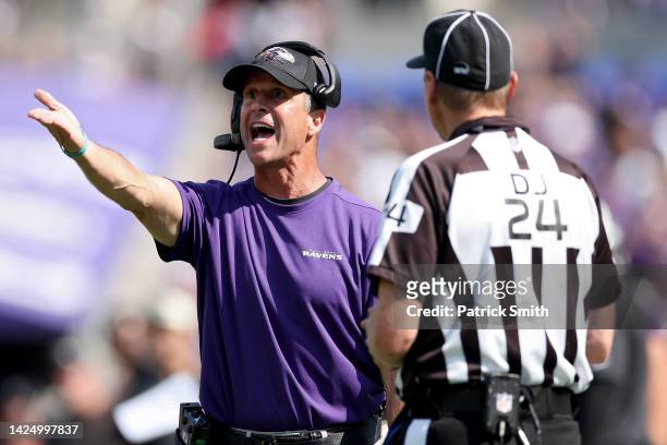 Baltimore Ravens head coach John Harbaugh talks to down judge David Oliver during the second half against the Miami Dolphins at M&T Bank Stadium on...