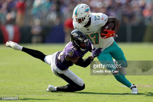 Jaylen Waddle of the Miami Dolphins carries the ball against Marcus Williams of the Baltimore Ravens in the second half at M&T Bank Stadium on...
