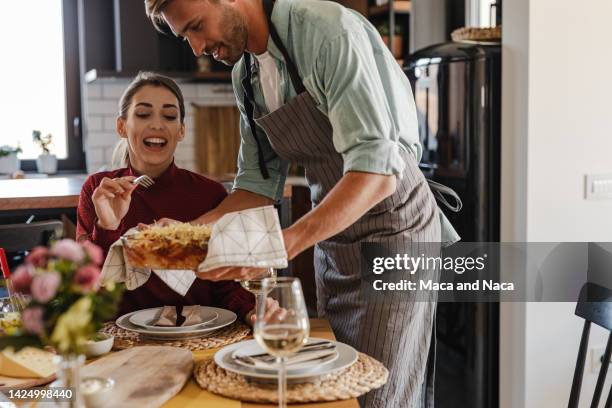 junger mann hat zu hause essen für seine freundin zubereitet - wein und kochen stock-fotos und bilder