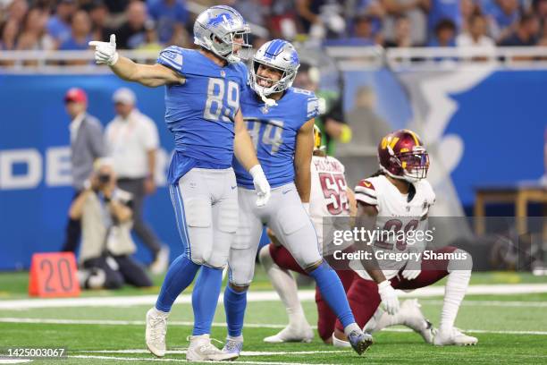 Brock Wright and Shane Zylstra of the Detroit Lions reacts after a first down against the Washington Commanders during the fourth quarter at Ford...