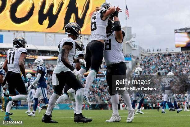 Trevor Lawrence celebrates with Brandon Scherff of the Jacksonville Jaguars in the second half against the Indianapolis Colts at TIAA Bank Field on...