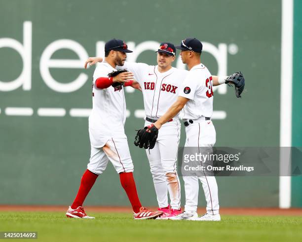 Tommy Pham, Enrique Hernandez and Rob Refsnyder of the Boston Red Sox react in the outfield after the victory over the Kansas City Royals at Fenway...