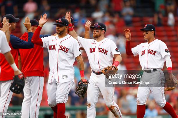 Tommy Pham, Christian Arroyo and Yu Chang of the Boston Red Sox high five teammates after the victory over the Kansas City Royals at Fenway Park on...