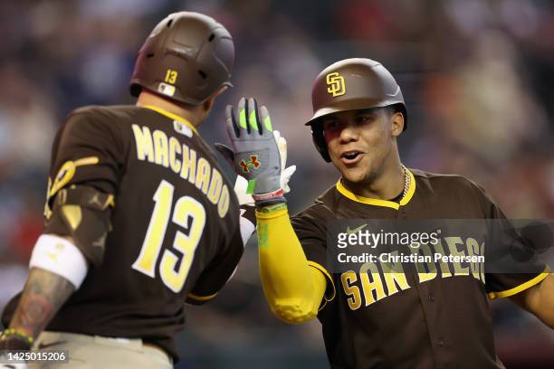 Juan Soto of the San Diego Padres high fives Manny Machado after hitting a solo home run against the Arizona Diamondbacks during the fifth inning of...