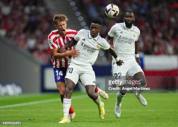 Marcos Llorente of Atletico de Madrid battles for possession with Vinicius Junior of Real Madrid during the LaLiga Santander match between Atletico...