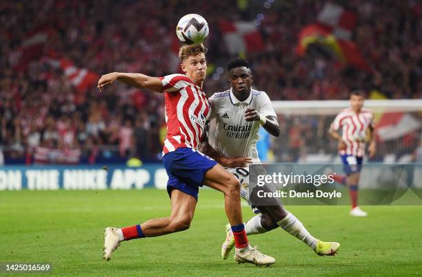 Marcos Llorente of Atletico de Madrid battles for possession with Vinicius Junior of Real Madrid during the LaLiga Santander match between Atletico...