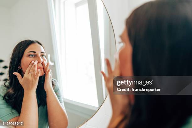 mujer que usa maquillaje en el baño - imagen virada fotografías e imágenes de stock