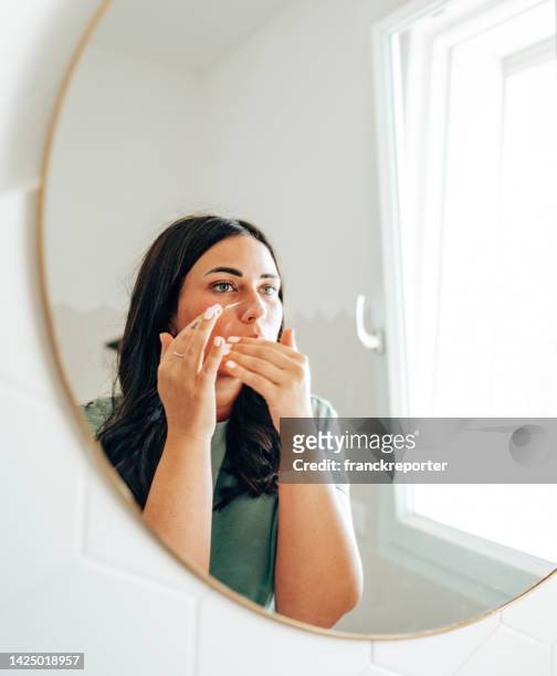 woman using make up in the bathroom - woman washing face stockfoto's en -beelden