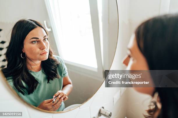 woman using make up in the bathroom - woman make up face wipes not men stock pictures, royalty-free photos & images