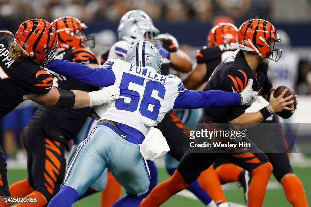 Dante Fowler Jr. #56 of the Dallas Cowboys grabs onto Joe Burrow of the Cincinnati Bengals during the first half at AT&T Stadium on September 18,...