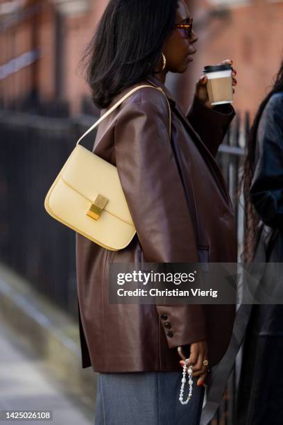 Guest wears beige Celine bag, brown blazer outside 16Arlington during London Fashion Week September 2022 on September 18, 2022 in London, England.