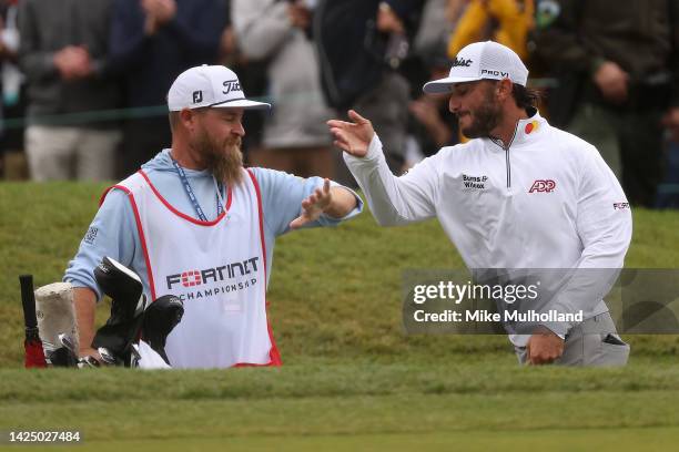 Max Homa of the United States celebrates with his caddie after chipping in for birdie on the 18th hole during the final round of the Fortinet...