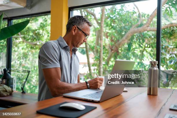man working on laptop in the office - working in remote location stock pictures, royalty-free photos & images