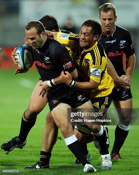 Frederic Michalak of the Sharks is tackled by Jack Lam of the Hurricanes during the round seven Super Rugby match between the Hurricanes and the...