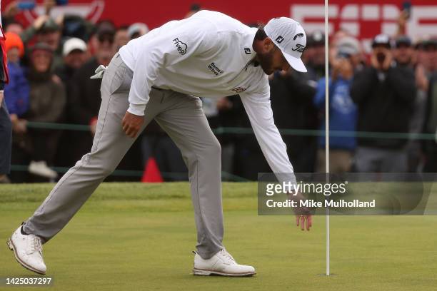 Max Homa of the United States retrieves his ball after chipping in for birdie on the 18th hole during the final round of the Fortinet Championship at...