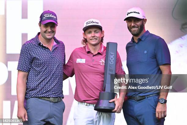 Team Captain Cameron Smith of Punch GC poses with the trophy on the podium alongside Team Captain Dustin Johnson of 4 Aces GC and Peter Uihlein of...