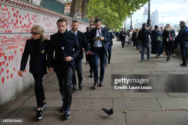 French President Emmanuel Macron and First Lady Brigitte Macron walk next to the people queueing to see Queen Elizabeth II lying in state in...