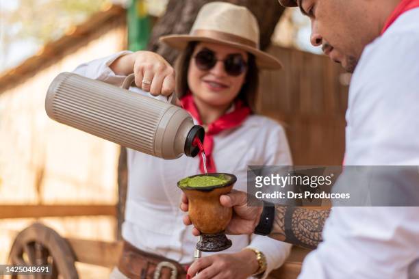 gaucho-paar trinkt chimarrao im farroupilha-camp - yerba mate stock-fotos und bilder