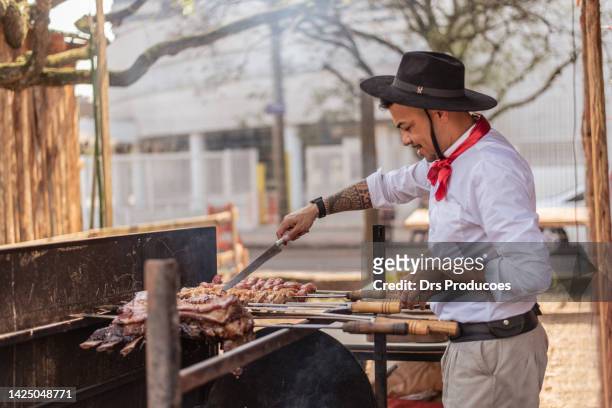 gaucho making barbecue at the farroupilha camp - rio grande do sul stockfoto's en -beelden