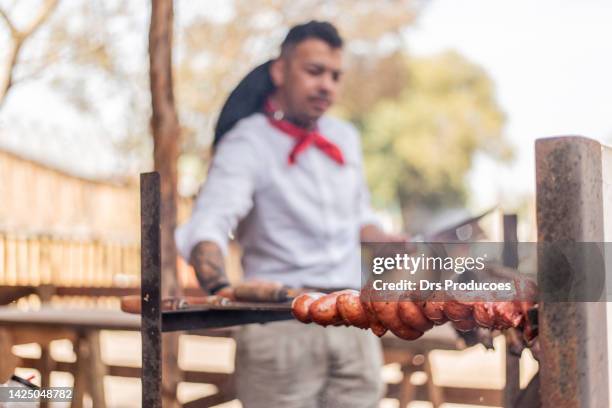 gaucho making barbecue at the farroupilha camp - gaucho festival stock pictures, royalty-free photos & images