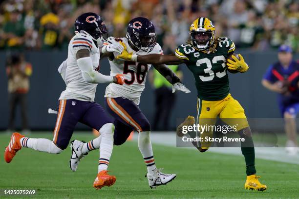 Aaron Jones of the Green Bay Packers is chased by Eddie Jackson and Roquan Smith of the Chicago Bears during the second half at Lambeau Field on...