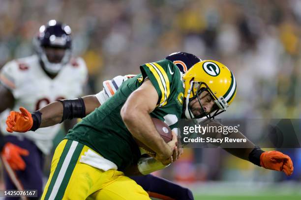 Aaron Rodgers of the Green Bay Packers is tackled by Al-Quadin Muhammad of the Chicago Bears during the fourth quarter at Lambeau Field on September...